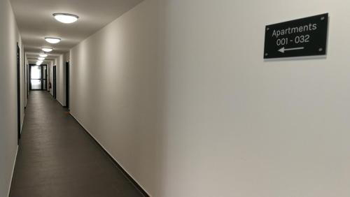 an empty hallway with a sign on the wall at Myroom Business Apartment Nähe Messe München in Munich