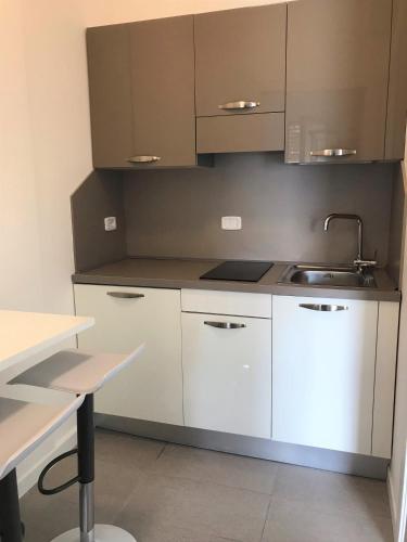 a kitchen with white cabinets and a sink at Residence Acquasuite in Martinsicuro