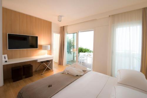 a bedroom with a bed with a desk and a television at Dilman Luxury Stay in Bari
