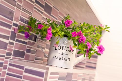 a flower pot with flowers and garden written on it at Apartment Auretta in Novigrad Istria