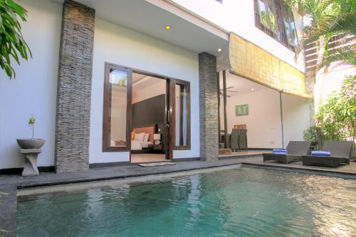 a house with a swimming pool in front of it at Villa Raka Managed by Manara in Legian