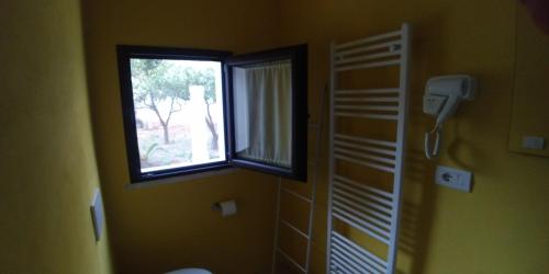 a bathroom with a window and a toilet in a room at Corte Piri in Tricase