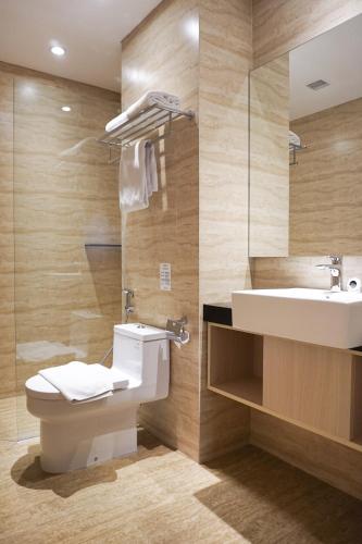 a bathroom with a toilet and a sink at Midtown Residence Simatupang Jakarta in Jakarta