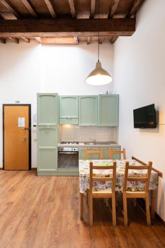 a kitchen with green cabinets and a table and chairs at Era Rental Apartments in Florence
