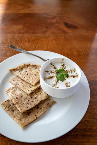 a plate with a bowl of soup and some crackers at Larisa Resort, Mussoorie in Mussoorie