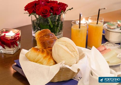 - une table avec un panier de pain et deux verres de jus d'orange dans l'établissement Motel Portofino, à Matosinhos