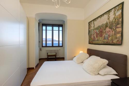 - une chambre avec un lit blanc orné d'une peinture murale dans l'établissement Palazzo BellaVista by Impero House, à Stresa