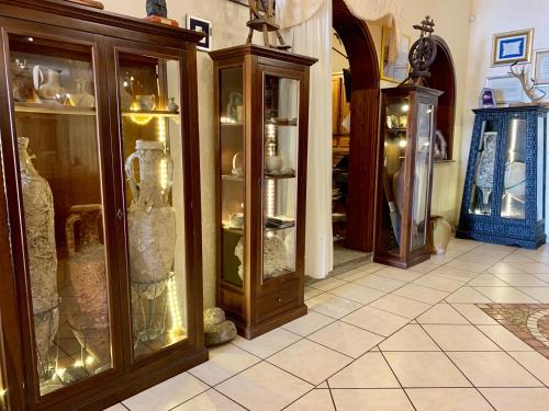 a room with glass cases with vases in it at Hotel Villaggio Ristorante Pizzeria Museo TANIT in Carbonia
