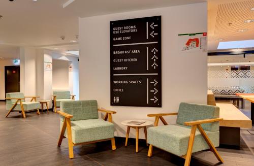 a waiting room with chairs and a chalkboard at MEININGER Budapest Great Market Hall in Budapest