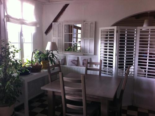 a dining room with a table and chairs and windows at Entre Mer et Pins in Saint-Julien-en-Born
