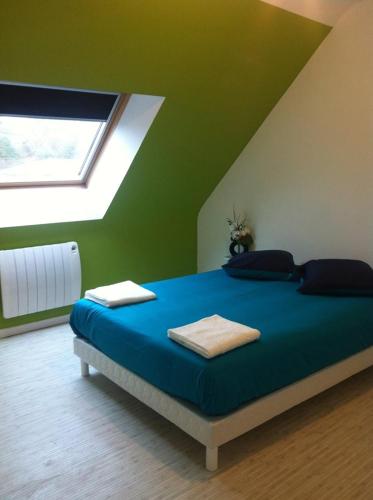 a bedroom with a bed with blue sheets and a window at 2 chambres doubles, 1chambre 4 lits simples, Salle de bains avec balnéo thérapie in Plaine-Haute