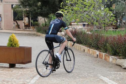 a man riding a bike down a street at Finca Agroturismo Son Menut in Felanitx