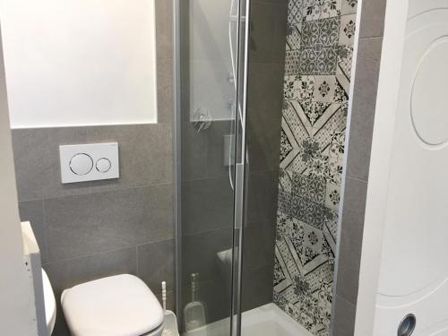 e bagno con servizi igienici e doccia in vetro. di Albergo Rosa a Cavallino-Treporti