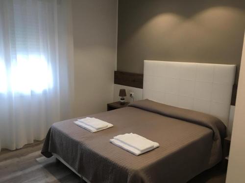 a bedroom with a bed with two towels on it at Albergo Rosa in Cavallino-Treporti