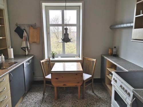 a kitchen with a table and chairs and a window at Struckshus in Tønder