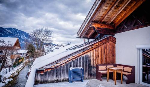 a house with a table and a chair on a balcony at Ferienhaus Butterfly in Garmisch-Partenkirchen