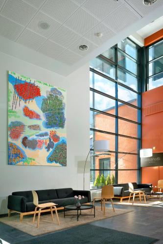 a lobby with couches and a map on the wall at Hotel Lasaretti in Oulu
