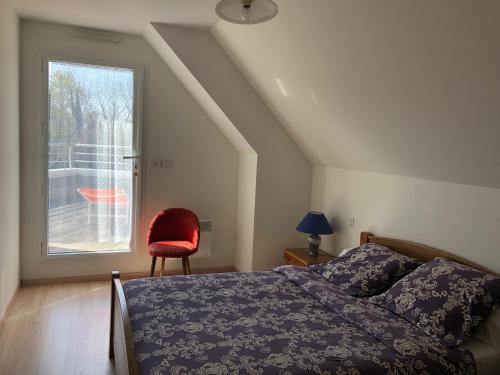 a bedroom with a bed and a chair and a window at Villa Benodet in Bénodet