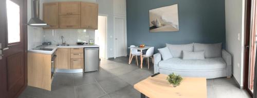 cocina y sala de estar con sofá y mesa en Light blue house 3 Apartments, en Poulithra