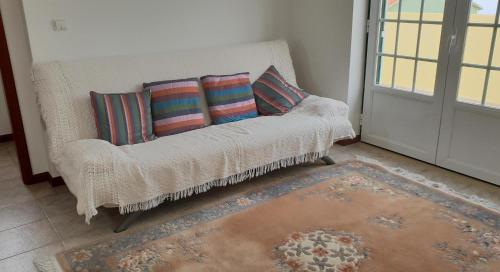 a couch with pillows in a room with a door at Casa Harmonica com vista mar in Areia Branca