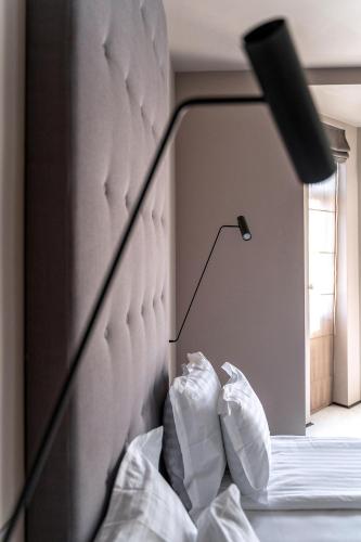 a headboard of a bed with a lamp and pillows at Design Hotel 36 in Sofia