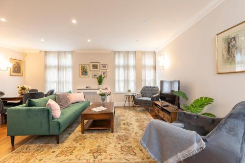 a living room with couches and a television at Beautiful 2 bed apt in the heart of Mayfair, close to Tube in London