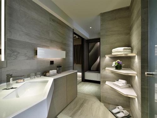 bagno con lavandino e vasca di Xi Hotel a Hong Kong