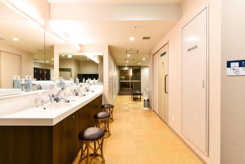 a bathroom with a row of sinks and mirrors at Hida Takayama Washington Hotel Plaza in Takayama