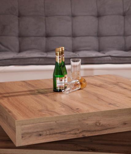 two bottles of beer and a glass on a wooden table at Ferienhaus Butterfly in Garmisch-Partenkirchen