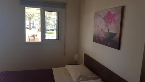 sypialnia z łóżkiem i oknem w obiekcie ZORBAS Sea View No 1 - Antoniella w Larnace
