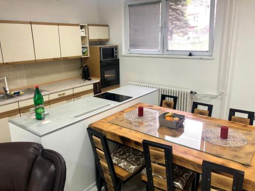 a kitchen with a wooden table and a counter top at Apartment on a river avenue in Pančevo