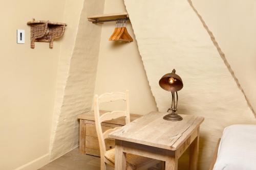 Zimmer mit einem Tisch, einem Stuhl und einer Lampe in der Unterkunft De Grote Wateringe in Damme