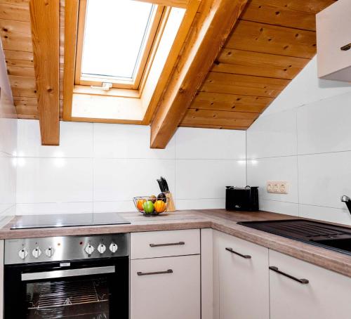 a kitchen with white cabinets and a stove top oven at Ferienhaus Butterfly in Garmisch-Partenkirchen