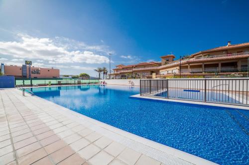 una gran piscina en un edificio de color azul en Apartamentos en Torres del Sol en Arona