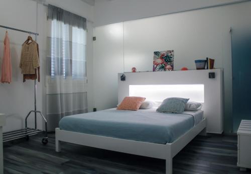a bedroom with a bed with a white headboard at Calida B&B in Castellammare del Golfo
