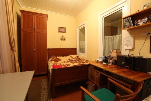 Ruzanna's Bed & Breakfast في ستيبانافان: غرفة نوم مع مكتب وسرير مع خزانة