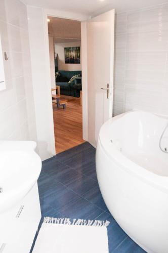 a bathroom with a white tub and a toilet at Stylish Apartment with Castle View & Free Parking in Ljubljana