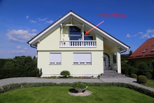 Ein weißes Haus mit einem roten Pfeil drauf. in der Unterkunft Ihre Auszeit am Golfplatz in Meisdorf