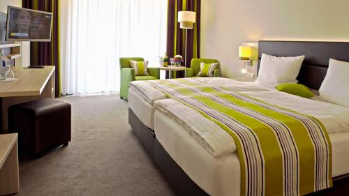 a hotel room with a large bed and chairs at Landgasthof Eiserner Ritter in Boppard