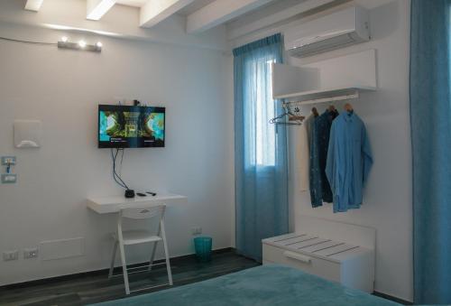a bedroom with a bed and a desk and a window at Calida B&B in Castellammare del Golfo