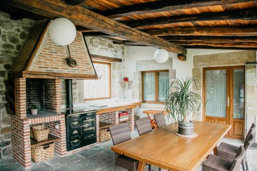 a living room with a wooden table and a fireplace at Jardín Botánico in Lloreda