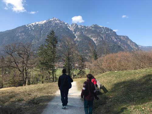 two people walking down a path with mountains in the background at Ferienhaus Butterfly in Garmisch-Partenkirchen