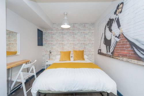 une chambre avec un lit et un mur de briques dans l'établissement The Loft Brighton, à Brighton et Hove