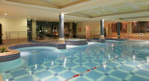 a swimming pool with a pool table and chairs at The Galmont Hotel & Spa in Galway