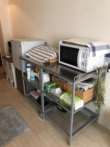 a microwave sitting on top of a table at 新大阪徒步30秒 Shinosaka Station 30s, Direct to Kansai Airport 關西空港直達, Shinkansen to Kyoto, Tokyo & Nagoya, Universal Studio 16 mins, Umeda 6 mins, Kyoto 25 mins, Early Check in in Osaka