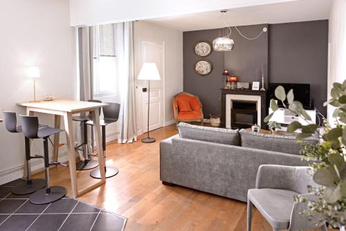 uma sala de estar com um sofá e uma mesa em Coeur du Boulingrin em Reims