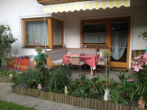 a patio with a table and chairs in front of a house at Ferienwohnungen Flörl in Zell am Ziller