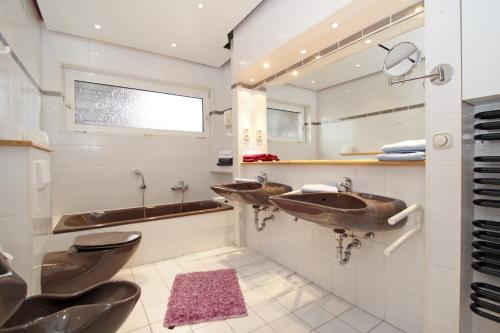 uma casa de banho com 2 lavatórios e 2 WC em Apartments Benser-Hof em Bensersiel