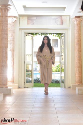 a woman walking down a hallway in a building at Rivoli Suites in Hurghada