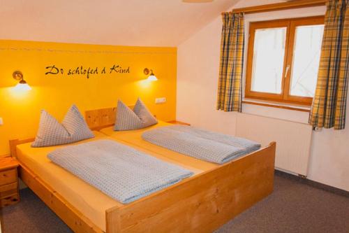 2 camas en un dormitorio con una pared amarilla en Reischhof, en Missen-Wilhams